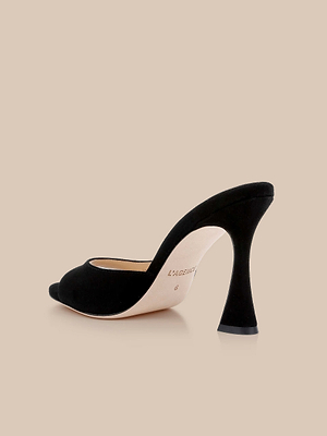 The Avery Suede Open-Toe Mule is a black suede sandal with a flared heel and beige sole, shown on a plain beige background.