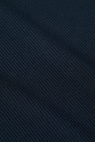 Close-up of the Ressi Micro-Rib Tee’s dark, ribbed microfiber fabric with diagonal textured lines, featuring fine, detailed stitching and a soft material appearance.