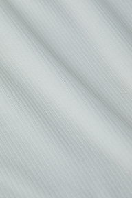 Close-up of the Ressi Micro-Rib Tee in white, showcasing its fine vertical ribbed texture and soft folds that create subtle shadows and highlights.