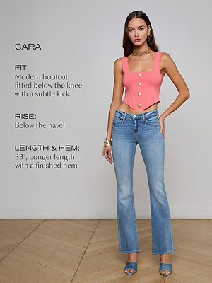 A woman models the L'AGENCE Sale Cara Low-Rise Bootcut Jean in blue stretch denim, featuring a modern bootcut, fitted below the knee, 33