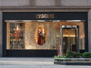 Storefront with 'L'Agence' sign and decorative window display.