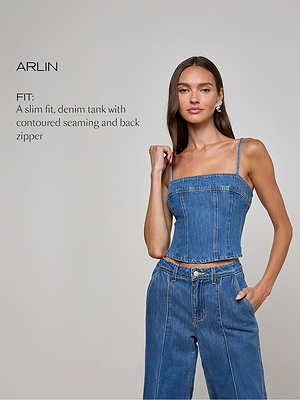 A woman with long brown hair wears a fitted, sleeveless denim tank top and matching high-waisted jeans. She stands against a plain light gray background with one hand in her pocket. Text beside her describes the fit of the top.