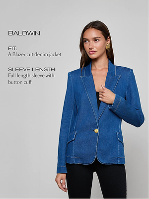 A woman wearing a blue denim blazer with gold button and white stitching stands against a plain background. Text describes the jacket as a blazer cut denim jacket with full length sleeve with button cuff.