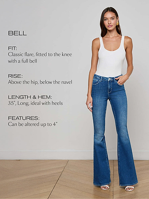 A woman wearing a white sleeveless top and blue flared jeans stands on a wooden floor. Text describes the jeans’ fit, rise, length, and alterable features.
