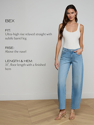 Woman wearing light blue jeans and a white tank top on a plain background with product details.