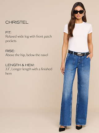 A woman wearing sunglasses, a white short-sleeve shirt, and wide-leg blue jeans with patch pockets stands against a beige background. Text beside her describes the jeans fit, rise, length, and finished hem.