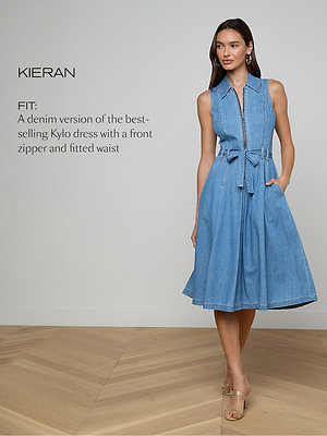 A woman stands in a light room wearing a sleeveless, knee-length blue denim dress with a front zipper and tie waist. She has long hair and is wearing sandals. Text beside her describes the dress fit and style.