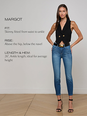 A woman wearing a black sleeveless vest and high-waisted blue skinny jeans stands with one hand in her pocket. Text describes the jeans: “Fit: Skinny, fitted from waist to ankle. Rise: Above the hip, below the navel. Length & Hem: 26”, ankle length, ideal for average height.”.