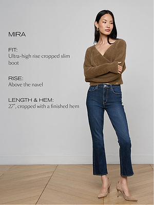 A woman stands with arms crossed, wearing a brown V-neck sweater, beige heels, and Mira Cropped Bootcut Jeans—blue, high-rise, stretch denim with a cropped micro bootcut. Text on the left describes the jeans’ fit, rise, and length.