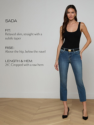 Woman wearing blue jeans and a black top with product details on a plain background