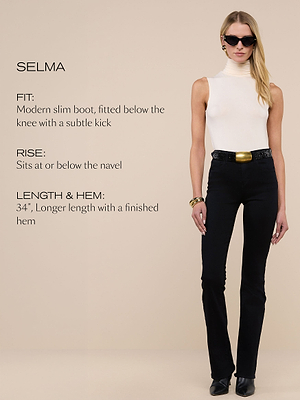A woman wearing a sleeveless white turtleneck top, black slim bootcut pants with a gold buckle belt, black shoes, sunglasses, and earrings stands against a beige background. Text describes the pants fit, rise, length, and hem.