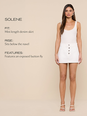 A woman stands against a beige background wearing a white tank top, a white mini length denim skirt with exposed button fly, and white sandals. Text on the left describes the skirts fit, rise, and features.