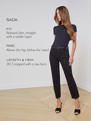 A woman stands in a minimal room wearing a black fitted t-shirt and cropped black jeans with a raw hem. Text beside her describes the jeans fit, rise, and length details.