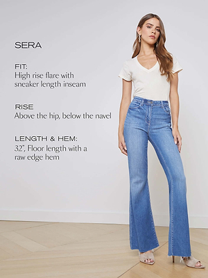A woman stands against a white wall wearing a white V-neck top and Sera Sneaker Flare Jean, featuring high rise, flare-leg in premium stretch denim, raw hem, and detailed fit and length info displayed on the image.