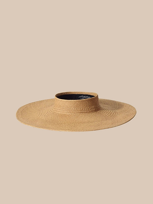 Das „Flor Visor“, ein handgefertigtes Visier mit breiter Krempe und flachem Schirm, wird vor einem beigen Hintergrund gezeigt. Sein offenes Gewebe bietet Sonnenschutz und unterstreicht zugleich sein schlichtes, natürliches Design.