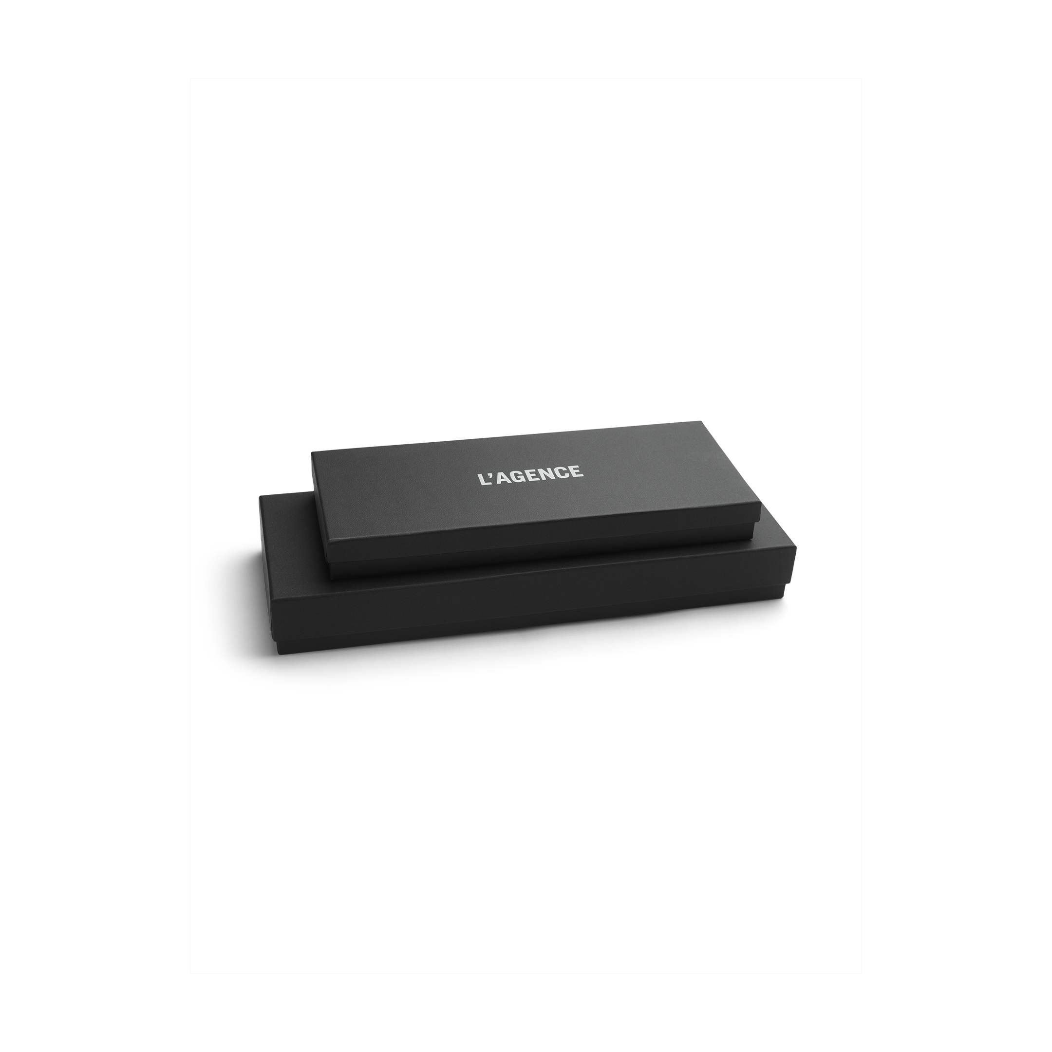 Two sleek black rectangular boxes are stacked, with the top box labeled LAGENCE in white, all set against a plain white background—evoking the refined elegance of Tempo Mittens by L’AGENCE.