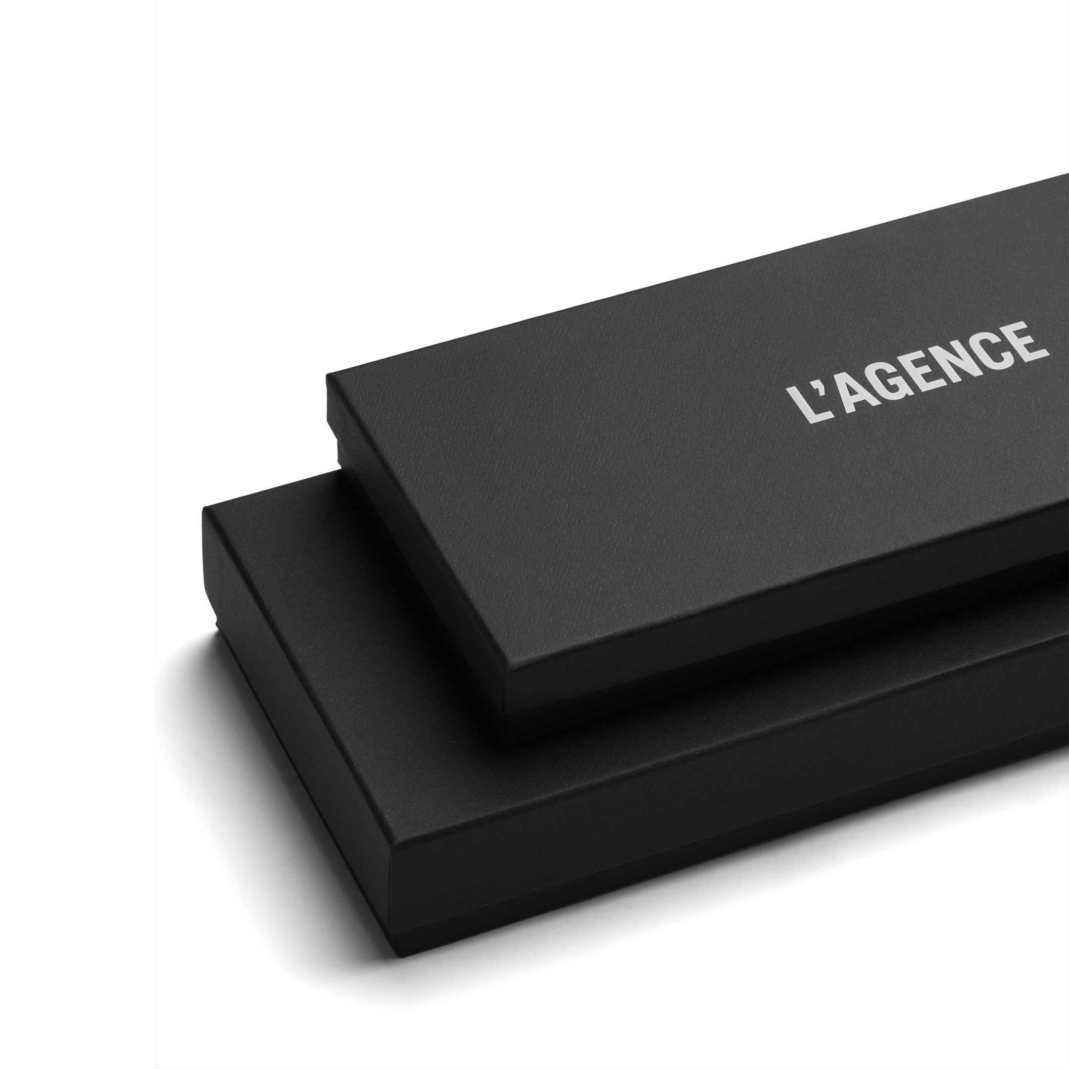 Two stacked black rectangular boxes, the top one slightly smaller and labeled LAGENCE in white text, set against a plain white background—an elegant presentation reminiscent of luxury accessories such as the Tempo Mittens.