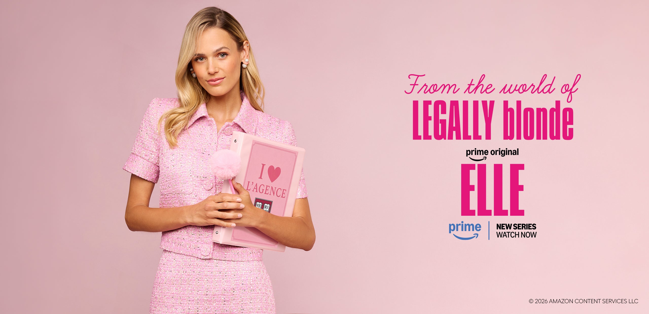 Una donna in abito rosa tiene in mano una cartellina rosa con la scritta “I ♥ LA GENERIC”, in piedi su uno sfondo rosa. Il testo recita: “Dal mondo di LEGALLY BLONDE, per promuovere la nuova serie di Prime Video ‘Elle’”.