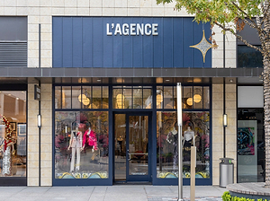 Storefront of L'AGENCE with glass windows displaying mannequins and clothing.