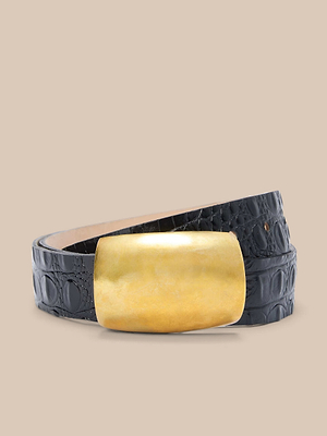 La ceinture Milou est fabriquée en cuir italien noir avec une finition gaufrée au crocodile et présente une grande boucle rectangulaire dorée, sur un fond beige uni.