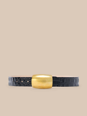 La ceinture Milou est une ceinture en cuir italien gaufré au croc noir, dotée dune large boucle rectangulaire en or, fabriquée à la main à Los Angeles et présentée sur un fond beige.