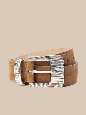 The Aya Suede Belt is a brown Italian suede belt with a large engraved silver buckle, handcrafted in LA and shown on a beige background.