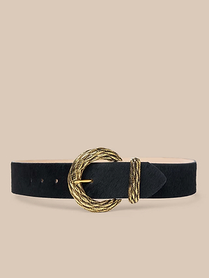 The Adelle Belt is a handcrafted black leather belt with a textured, gold-plated twisted rope-style oval buckle and matching loop, shown against a plain beige background.