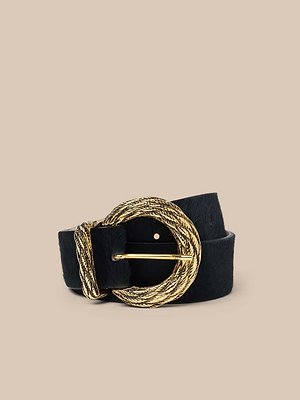 La ceinture Adelle est un accessoire en cuir fabriqué à la main, doté dune grande boucle ronde plaquée or et dune boucle dorée assortie, sur fond beige uni.