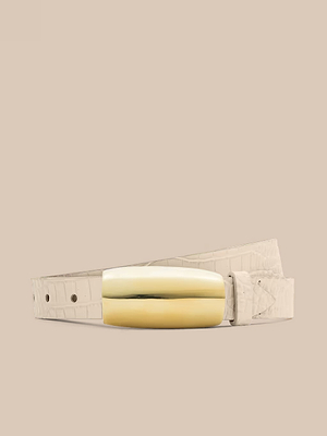 La cintura Marlowe Croc-Embossed Leather, in pelle avorio, presenta una grande fibbia placcata in oro, realizzata a mano a Los Angeles, su uno sfondo beige.