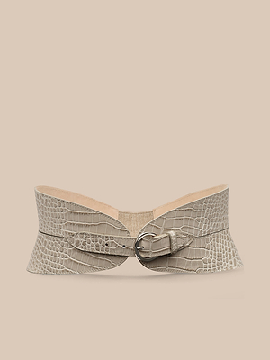 La cintura Alexandra Croc-Embossed Corset Belt presenta un motivo a coccodrillo color tortora, bordi svasati e una fibbia argentata. Realizzata a mano a Los Angeles, è presentata su un semplice sfondo beige.