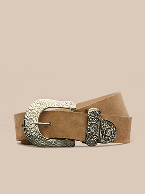 La ceinture en daim Otera, fabriquée à la main à Los Angeles, est dotée dune boucle, dun embout et dun passant en argent orné de motifs floraux gravés. Elle est présentée sur un fond beige.