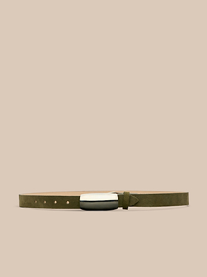 The Marlowe Suede Belt in olive green, featuring a silver-plated buckle, is showcased on a beige background—an ideal choice for minimalist tailoring.