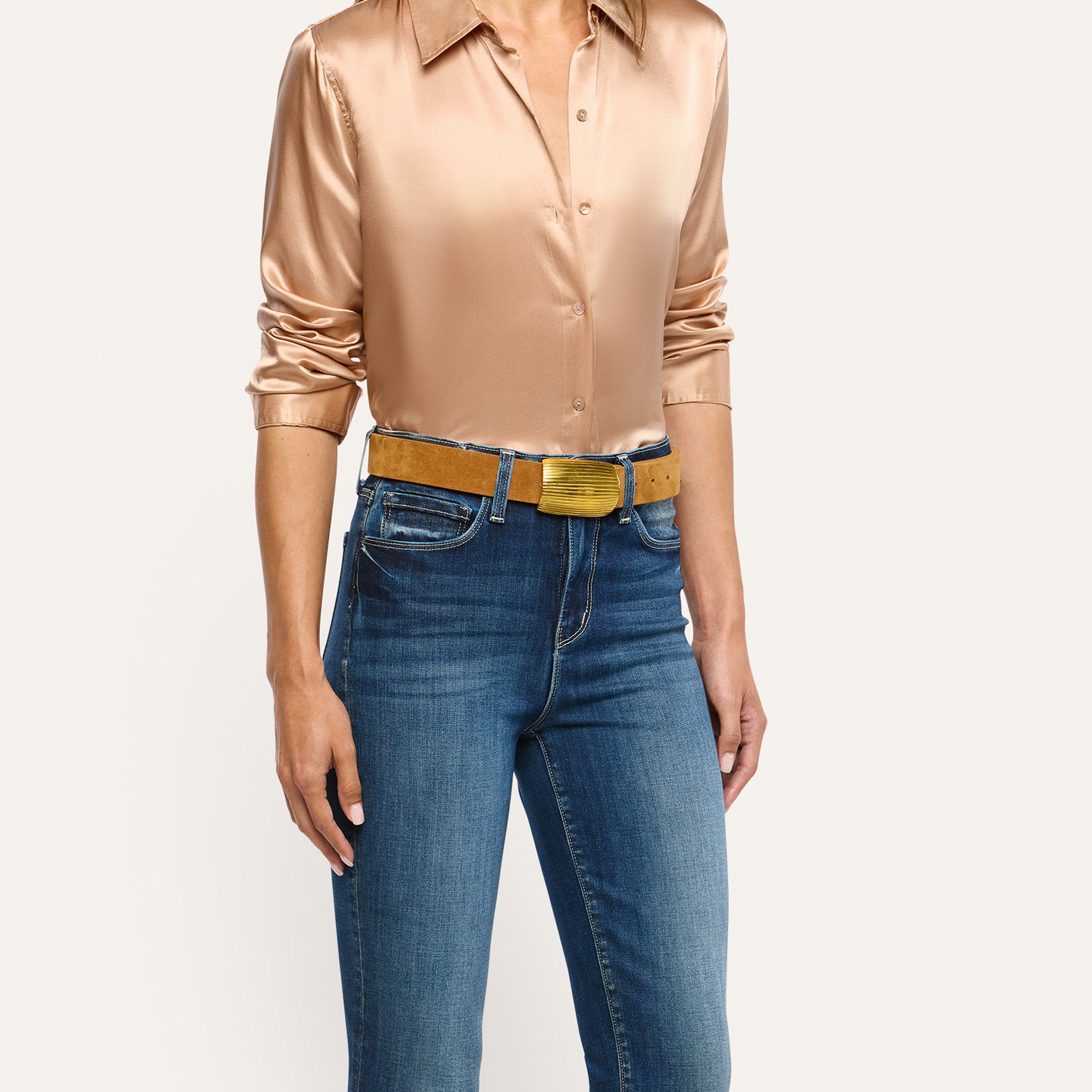 The Montell Suede Belt in cognac brown Italian suede with a textured gold buckle worn over blue jeans.