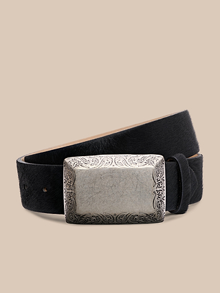 Introducing the Solera Belt: a handcrafted black calf hair belt with a large, rectangular gold-plated buckle engraved with decorative patterns, made in LA and showcased against a plain beige background.