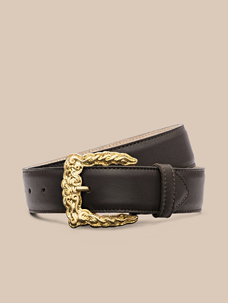 The Marcaeu Belt, handcrafted in LA from dark brown Italian leather, features an ornate gold-plated decorative buckle and is shown coiled on a plain beige background.