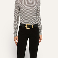 A person wearing an Italian calfsuede Caldera Suede Belt with an ornate gold-plated buckle over black pants and a black-and-white striped long-sleeve shirt.