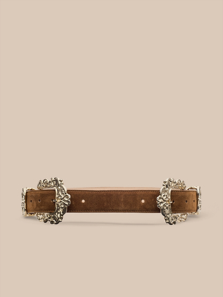 The Chayenne Suede Belt, handcrafted in LA from luxurious Italian suede in rich brown, features ornate silver decorative buckles at each end and is showcased against a beige background. This statement piece blends timeless style with exquisite craftsmanship.