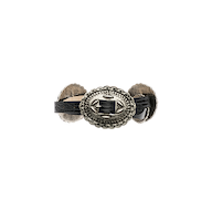 A decorative belt crafted from handcrafted Italian leather, featuring an ornate, silver-toned central medallion with intricate patterns and a black woven detail. The Rocha Leather Belt is finished with additional silver accents on each side.