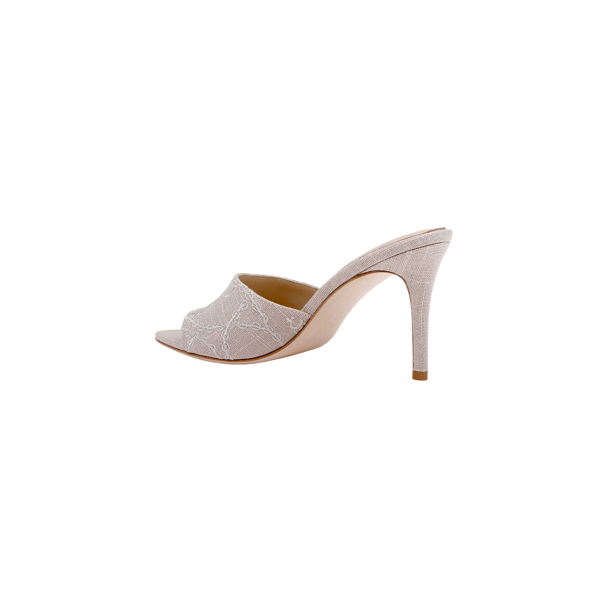 The Lolita Linen Open-Toe Mule in light beige features delicate white embroidery on embroidered linen, an open toe, and a slender stiletto heel, shown against a plain white background.