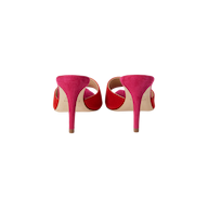 A pair of bright pink Lolita Suede Open-Toe Mules, featuring a stiletto heel and open-toe design, shown from the back against a plain white background.