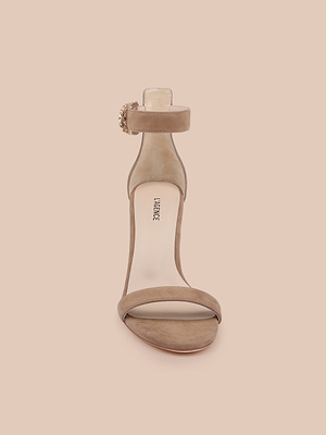 Il sandalo Gisele in pelle scamosciata color marrone caffè è caratterizzato da un design con tacco, cinturino alla caviglia e fibbia, mostrato frontalmente su uno sfondo beige chiaro. La scritta MICHAEL è stampata sul sottopiede.