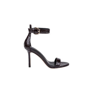 The Gisele Leather Sandal, crafted from black crocodile-embossed leather, features a high heel, an ankle strap, and a gold buckle, and is displayed on a plain white background.