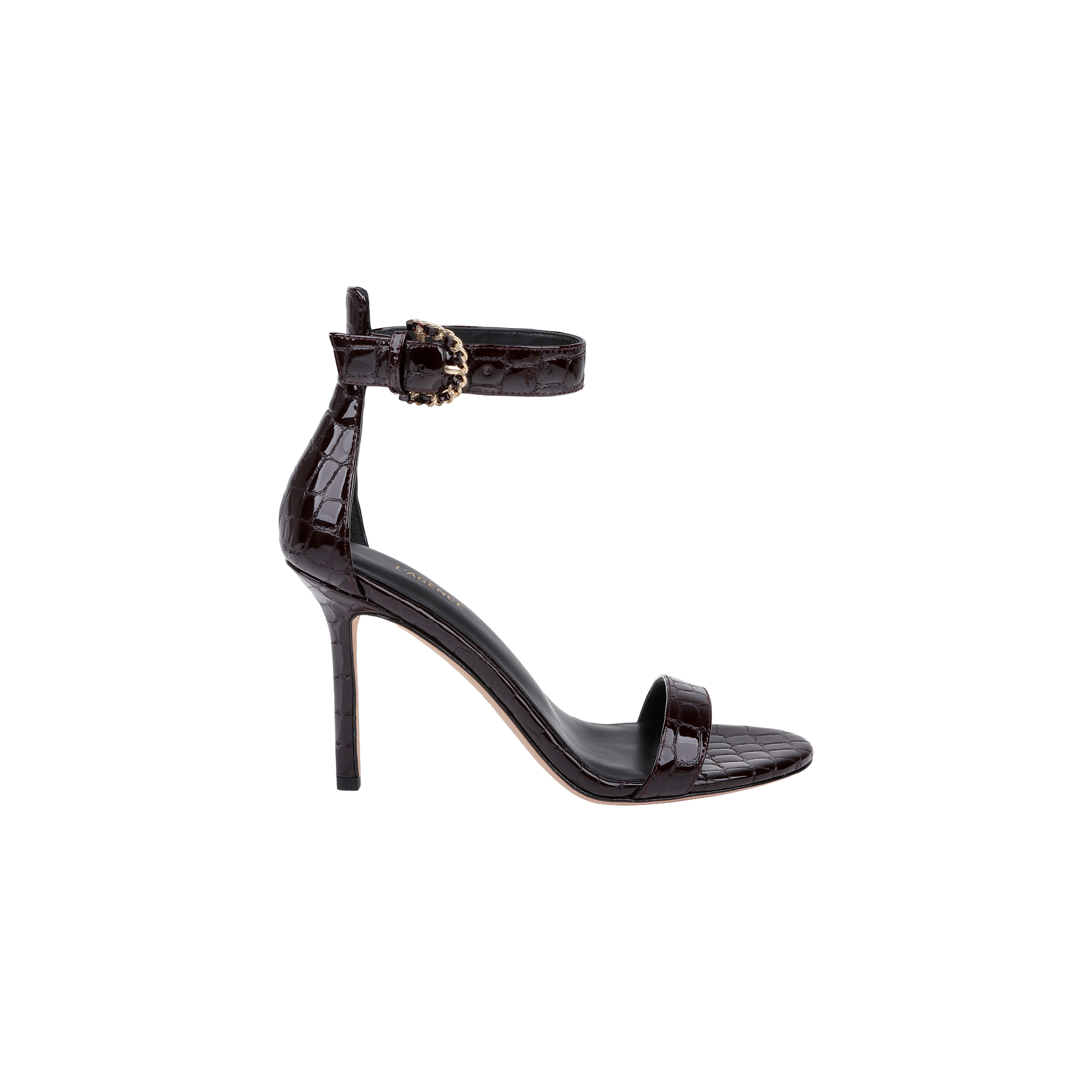 The Gisele Leather Sandal is a black, high-heeled shoe crafted from crocodile-embossed leather, featuring an ankle strap with a decorative buckle and a single toe strap, displayed in profile on a white background.