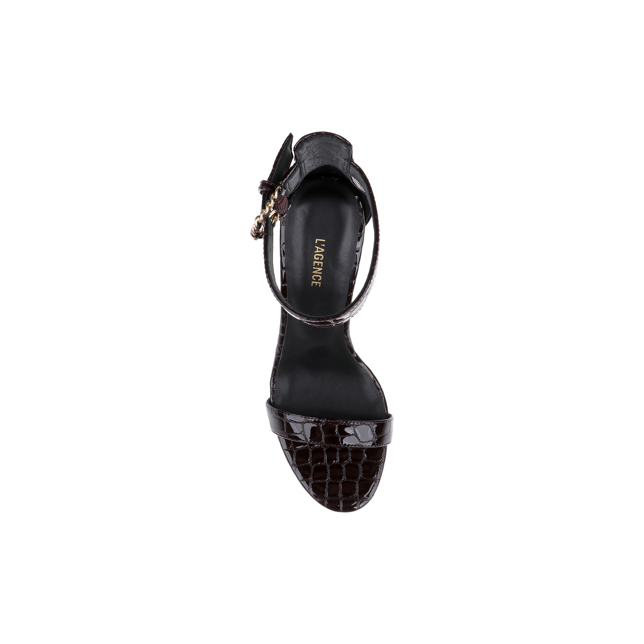 A black Gisele Leather Sandal, crafted with crocodile-embossed leather and an ankle strap adorned with a gold buckle, is displayed from above against a white background. The insole features the LARGRICE logo in gold lettering.