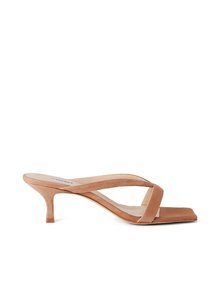 The Oceane Kitten Sandal is a minimalist, tan suede shoe with a low kitten heel, square toe, and wide crossing strap, displayed in profile against a white background.