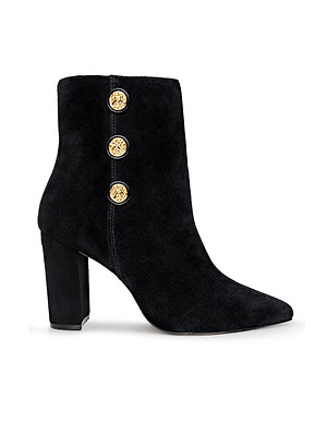 The Theodora Block-Heel Bootie is a chic black suede shoe with a pointed toe, sturdy block heel, and three vertical gold decorative buttons on the side.