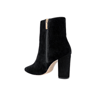 The Theodora Block-Heel Bootie is a black suede ankle boot with a chunky block heel, side zipper, and a slightly pointed toe, displayed on a white background.