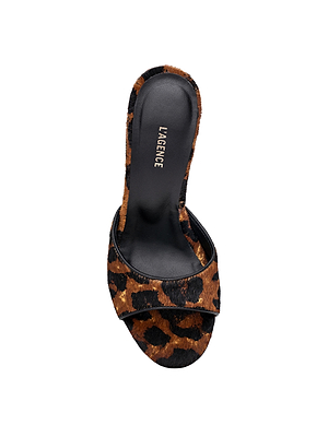 The Avery Open-Toe Mule features a wide black-and-brown leopard hair calf strap, a black footbed with the L’AGENCE logo in white, and a sculpted stiletto heel, all set against a clean white background.