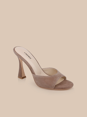 The Avery Suede Open-Toe Mule features a tan suede finish, sculpted heel, wide strap, and memory foam insole, shown against a neutral beige background.