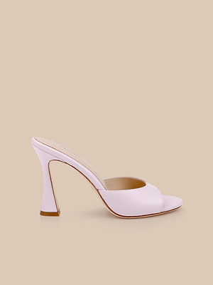 The Avery Leather Open-Toe Mule in pale pink lilac features a sculpted, curved heel and is shown on a beige background.